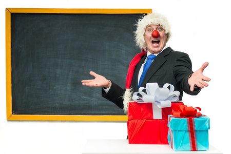 Santa Claus with gifts near the blackboardの写真素材