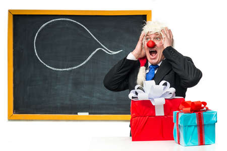 Santa Claus with gifts near the blackboardの写真素材