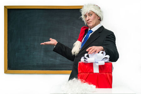 Santa Claus with gifts near the blackboardの写真素材