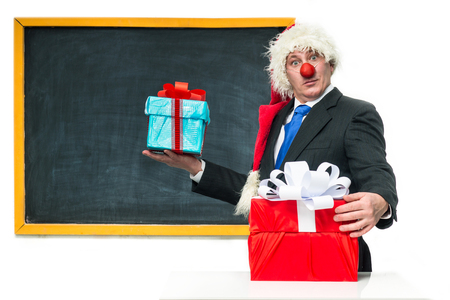 Santa Claus with gifts near the blackboardの写真素材