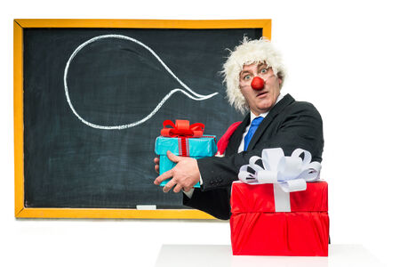 Santa Claus with gifts near the blackboardの写真素材