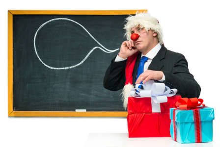 Santa Claus with gifts near the blackboardの写真素材