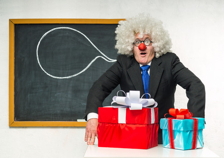 Clown with Christmas gifts near the blackboardの写真素材