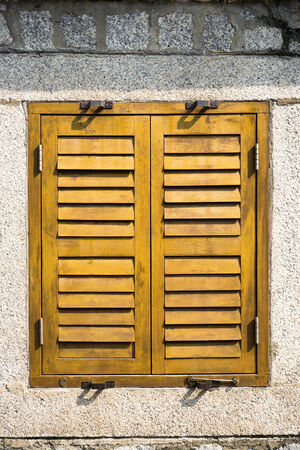 Closed wooden window blinds on the wallの写真素材