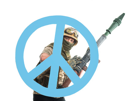 Soldier with a weapon and symbol of pacifismの写真素材