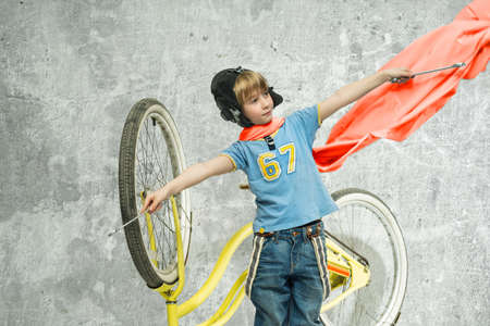 Boy in a red scarf repairing a bicycleの写真素材