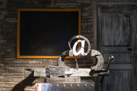 Sign of e-mail in grip on a background of blackboardの写真素材