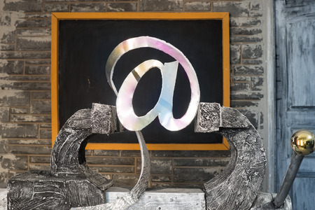 Sign of e-mail in grip on a background of blackboardの写真素材
