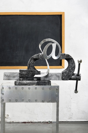Sign of e-mail in grip on a background of blackboardの写真素材
