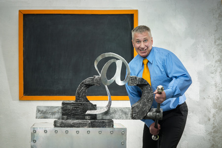 Man breaks sign of e-mail in gripの写真素材