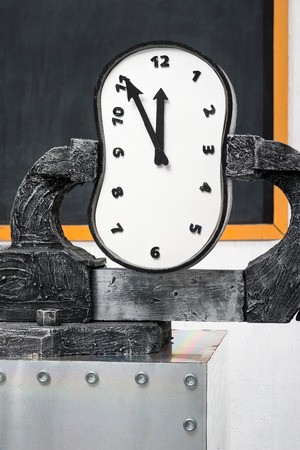 A time in a vise on a background of a blackboard