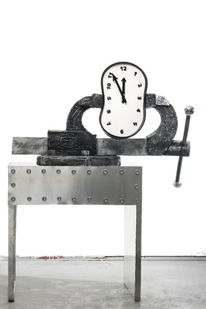 A time in a vise on a background of white wallの写真素材