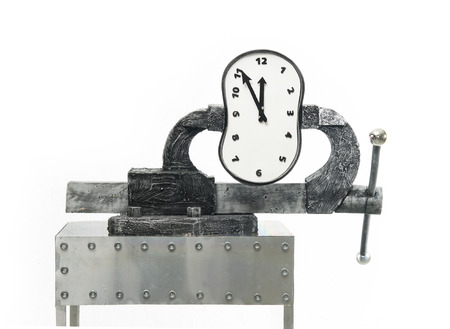A time in a vise on a background of white wallの写真素材