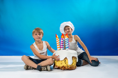 Cheerful confectioner and boy near a birthday cakeの写真素材