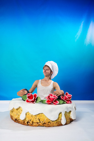 Funny confectioner sitting in the cakeの写真素材