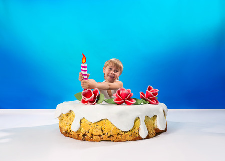 Cheerful boy sitting in the cakeの写真素材