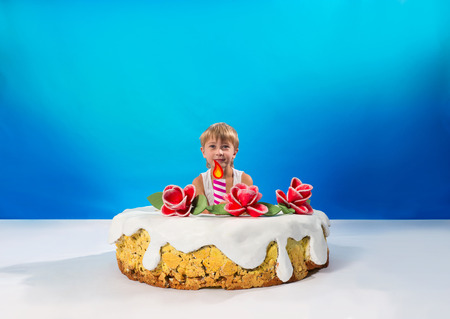 Cheerful boy sitting in the cakeの写真素材