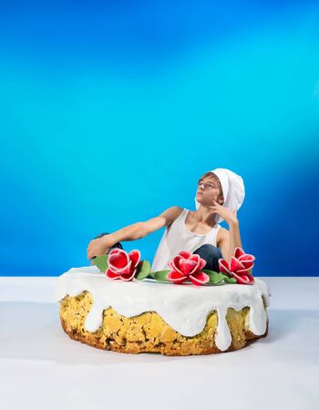 Funny confectioner sitting in the cakeの写真素材