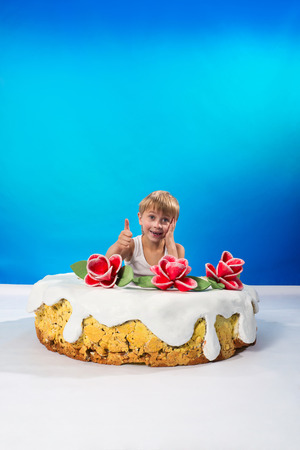 Cheerful boy sitting in the cakeの写真素材