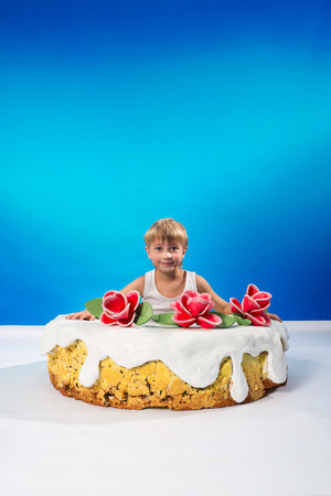 Cheerful boy sitting in the cakeの写真素材