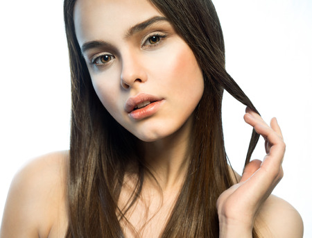 Portrait of a beautiful girl with a brown hair on the white backgroundの写真素材
