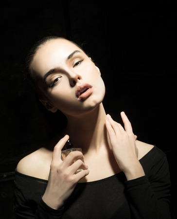 Portrait of a beautiful girl with a perfume bottleの写真素材