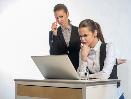 Two thoughtful businesswomen work at the laptopの写真素材