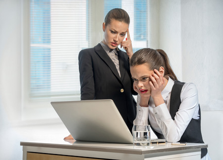 Two thoughtful businesswomen work at the laptop in officeの写真素材