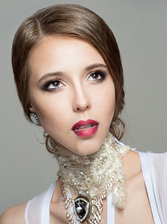 Portrait of a beautiful woman with brown hair on a gray backgroundの写真素材