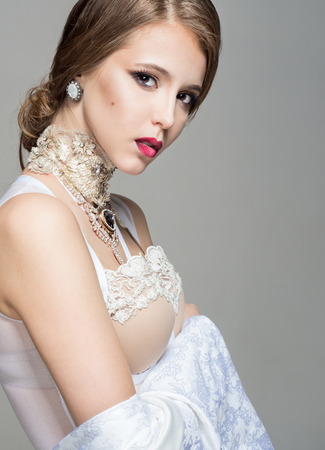 Sensuality woman with brown hair in a white lingerie on a gray backgroundの写真素材