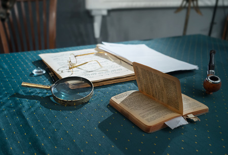 Table with books and tobacco pipe in the room