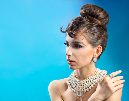 Portrait of a beautiful woman in profile with hairstyle on a blue backgroundの写真素材