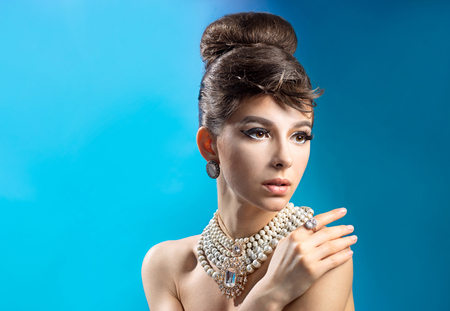 Portrait of a beautiful girl with hairstyle on a blue backgroundの写真素材