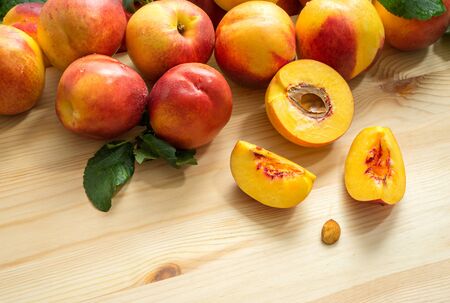 Half of peach and whole peaches on the wooden tableの写真素材