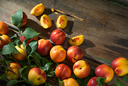 Beautiful peaches  and slices of peach on the old wooden boardsの写真素材
