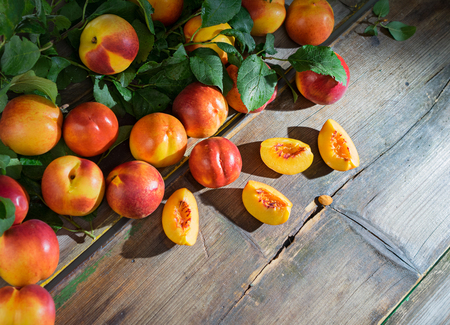 Beautiful peaches  and slices of peach on the old wooden boardsの写真素材
