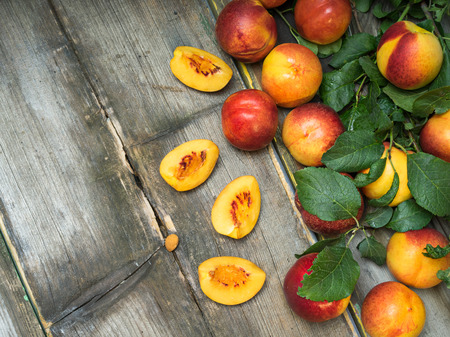 Beautiful peaches  and slices of peach on the old wooden boardsの写真素材