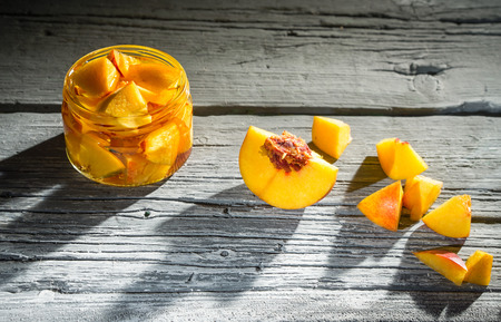 Peach jam in a glass jar on a old wooden tableの写真素材