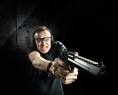 Gun in the hands of the crazy man in a headphones の写真素材
