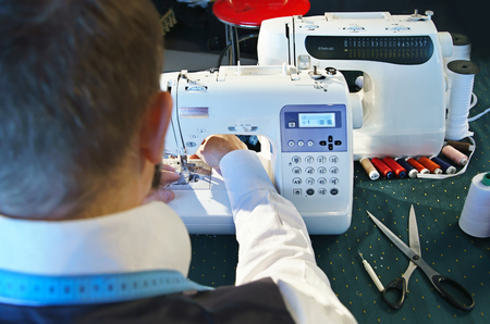 Couturier sews a dress on the sewing machineの写真素材