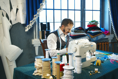 Couturier sews a dress on the sewing machine in the studioの写真素材