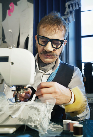 Couturier sews a dress on the sewing machine in the studioの写真素材