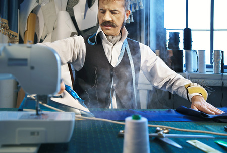Tailor irons the pants in the studioの写真素材