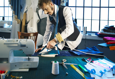 Tailor irons the pants in the studioの写真素材