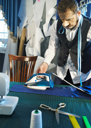 Tailor irons the pants in the studioの写真素材