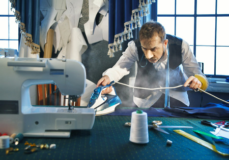 Tailor irons the pants in the studioの写真素材