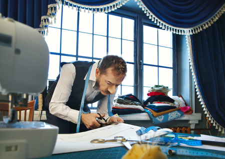 Designer cuts a template of a dress with scissorsの写真素材