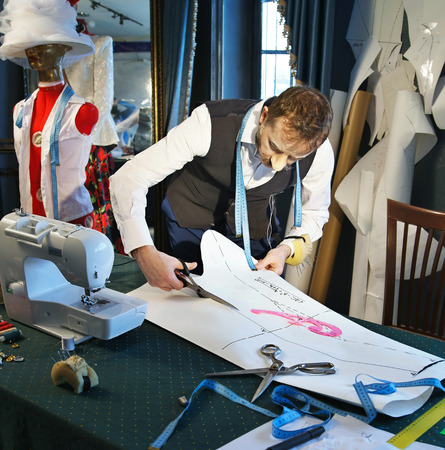 Designer cuts a template of a dress with scissorsの写真素材