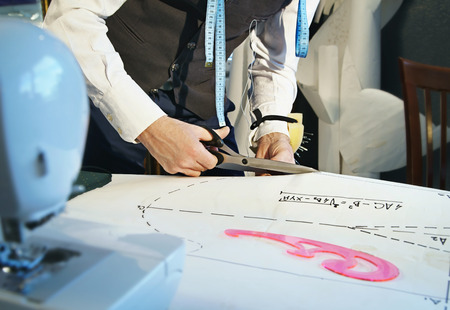 Designer cuts a template of a dress with scissorsの写真素材