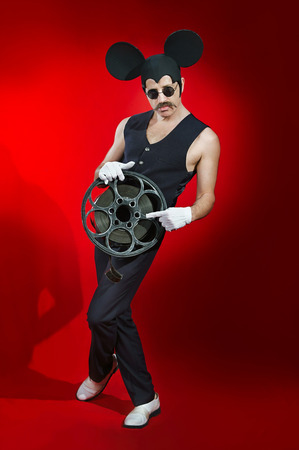 Man in a hat of a mouse with a reel of filmの写真素材
